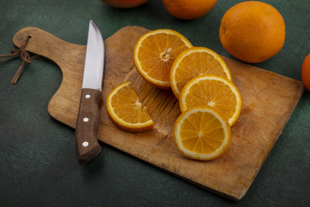 刀侧视图橙色与刀和绿色背景上的葡萄柚砧板水果板葡萄柚