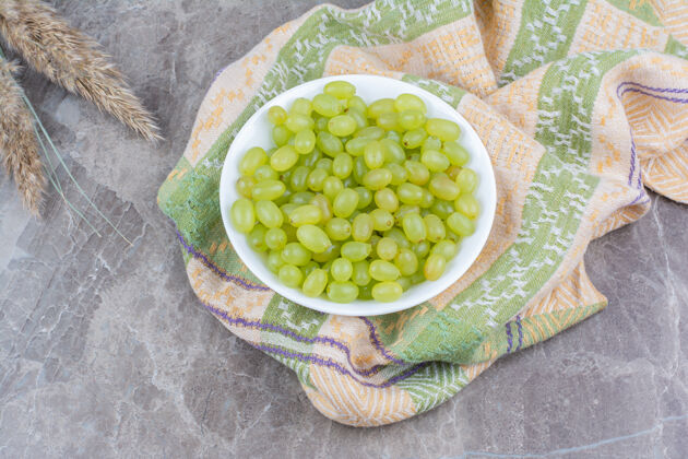 自然一碗绿葡萄放在五颜六色的桌布上葡萄植物绿色