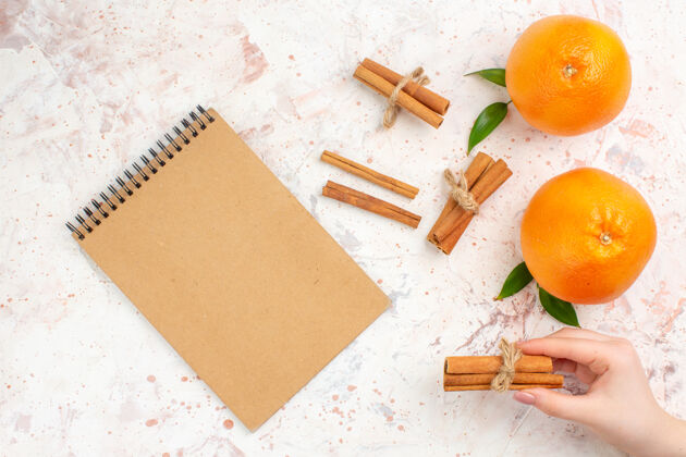 胡萝卜顶视图新鲜橙子肉桂贴在明亮的表面笔记本板子笔记本观点