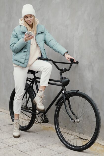 城市坐在自行车上用手机的女人交通体育城市