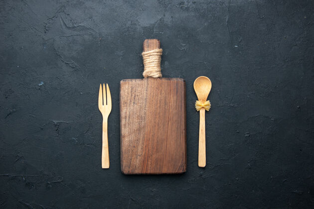 叉子顶视图砧板木勺和叉子在黑暗的表面复制空间法律手工工具勺子