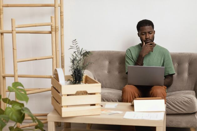 生活方式沙发上的男人正在计划用笔记本电脑重新装修房子想法房子人
