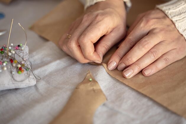 面料用针线缝纫的高视角女人裁缝细节手工制作