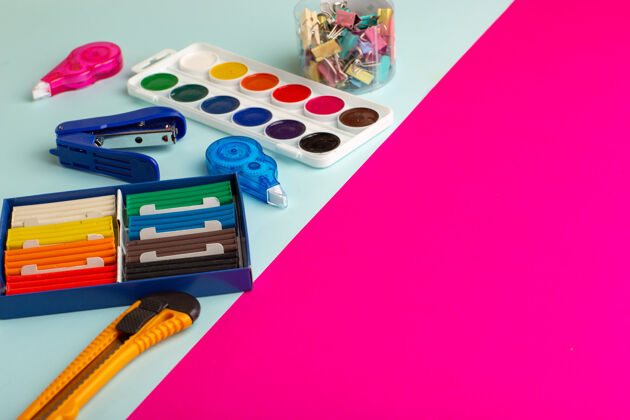 正面前视图彩色油漆与橡皮泥在蓝粉色的表面学校钢笔设备