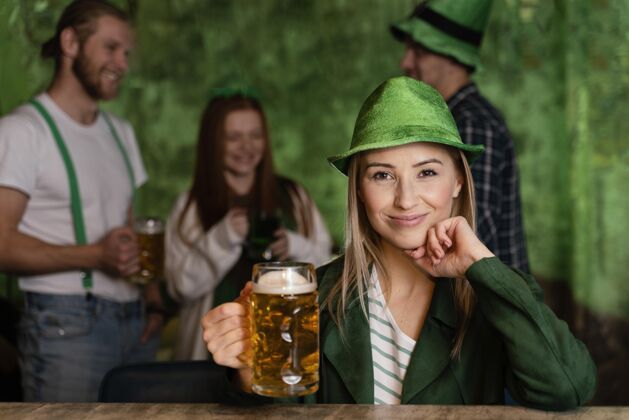 水平戴着帽子的笑脸女人的正面图 她和朋友们一起庆祝圣帕特里克节三叶草爱尔兰庆祝