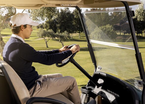 活动男子驾驶高尔夫球车侧视图运动娱乐消遣