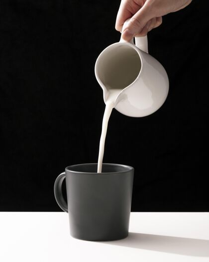 生活方式手往杯子里倒牛奶的正面图极简简单垂直