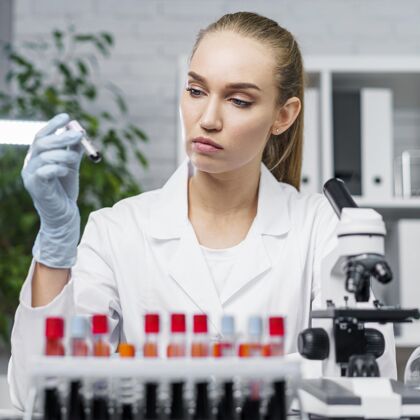 知识分子女研究员拿着试管在实验室里的正视图技术员女人技术员