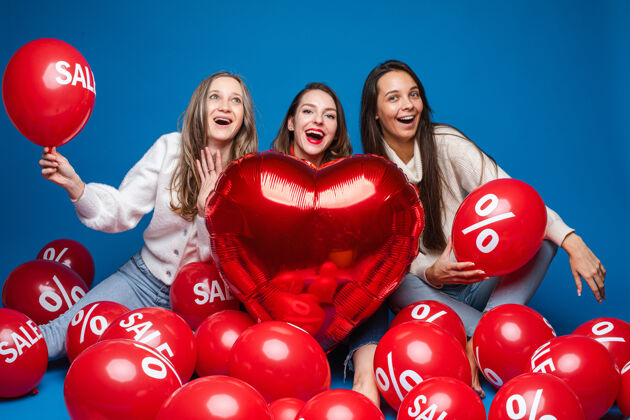 女孩快乐的女性朋友与红色心形气球合影年轻问候朋友