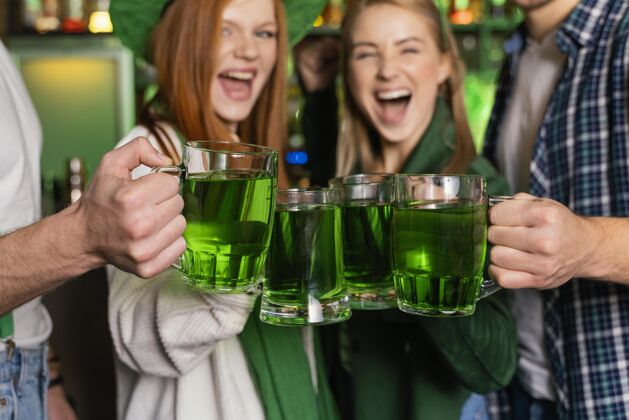 圣帕特里克日在酒吧庆祝圣帕特里克节的笑脸人的前视图爱尔兰场合饮料