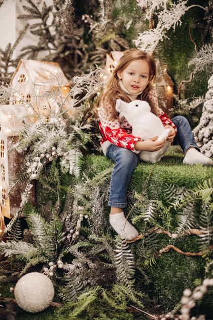 圣诞树站在圣诞装饰楼上的女孩毛衣美丽树枝