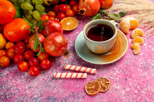 饮食在浅粉色的桌子上放一杯茶 可以看到新鲜水果的构成树新鲜水果