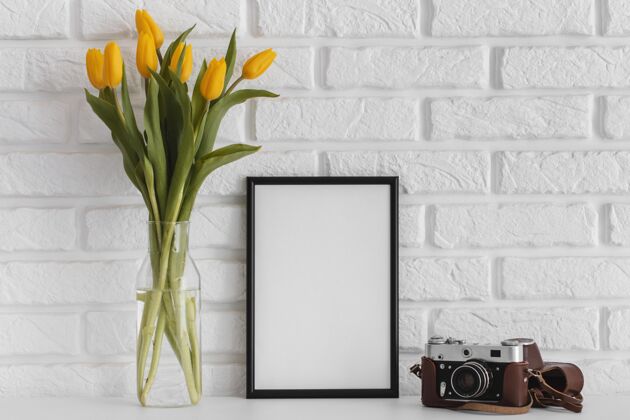 美丽一束郁金香放在透明花瓶里 空框和相机春天花卉季节