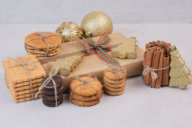 食物用绳子做的糕点 白色表面上有礼物和圣诞金球盒子面包房美味