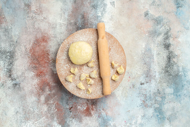 饼干顶视图杜什巴拉面团擀面杖上的面团糕点板上的裸体表面复制空间早餐面包顶部