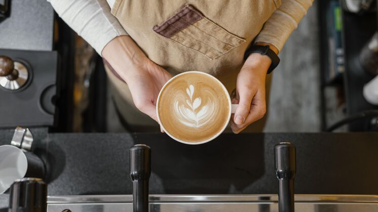 服务员女咖啡师端着一杯咖啡的俯视图职业就业女