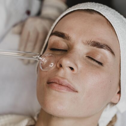 女性在健康中心接受面部皮肤治疗的女人美容健康平方