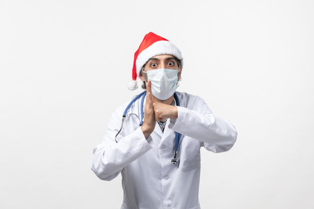 冠状病毒正面图戴着口罩的男医生白墙病毒假日大流行病毒圣诞节男医生医生
