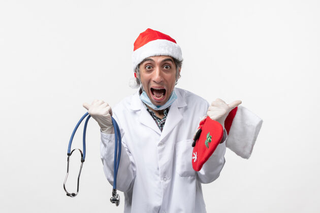 视图正面图：男医生在白墙病毒冠状病毒假日欢欣鼓舞职业圣诞节医药