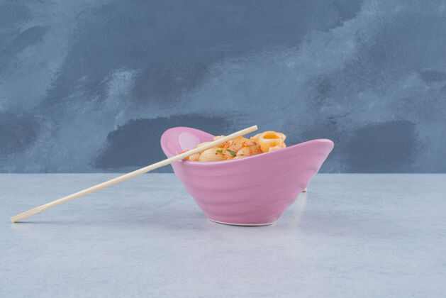 盘子美味的粉红色盘子 上面放着通心粉和筷子可食用吃好吃