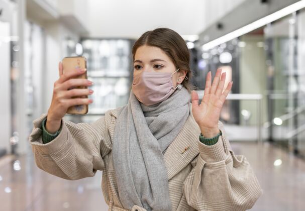 病毒戴着医用面罩的女人在打视频电话防护安全人