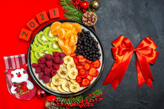 蔬菜餐桌上收集新鲜水果的俯视图装饰配件杉木树枝和数字上的红色餐巾和红丝带餐盘新鲜午餐
