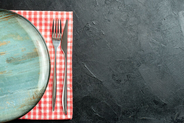 杯子顶视图圆形拼盘餐刀和餐叉上的红色和白色方格餐巾上的黑色桌子与自由空间景观顶部现金