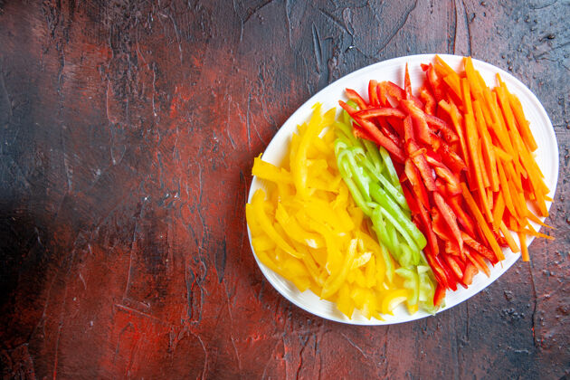辣椒顶视图五颜六色的切辣椒放在白盘子上 暗红色的桌子上抄地方菜肴辣椒盘子