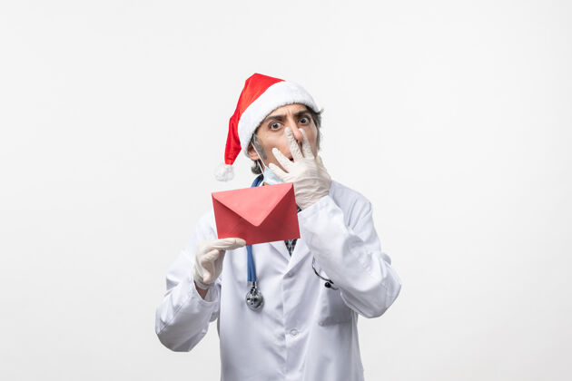 圣诞节正面图白墙上手持红包的男医生健康冠状病毒医院医生医院男医生