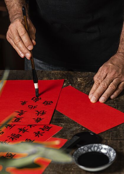 写作在红纸上写中国符号的人构图创意毛笔