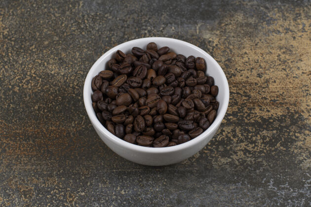 烘焙芳香的咖啡豆在白碗里咖啡种子庄稼