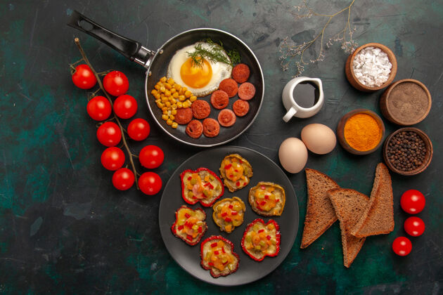 可食用的水果顶视图熟甜椒炒鸡蛋面包和香肠在深绿色的表面顶部食物早餐