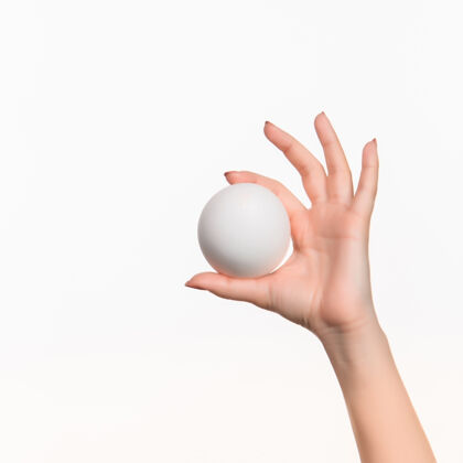 手臂女的手拿着白色的空白泡沫塑料球对着白色的泡沫球手指