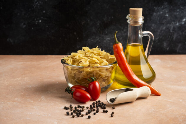 意大利面把生面食 蔬菜和一瓶油放在桔子桌上干的食品有机