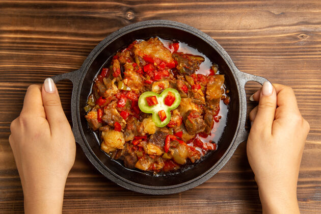 美味在棕色桌子上的锅里俯瞰煮熟的蔬菜餐平底锅菜肉