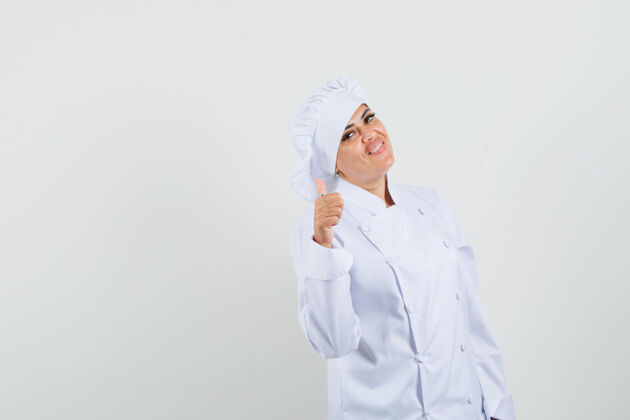 职业身着白色制服的女厨师竖起大拇指 看上去很快乐烹饪工作工作