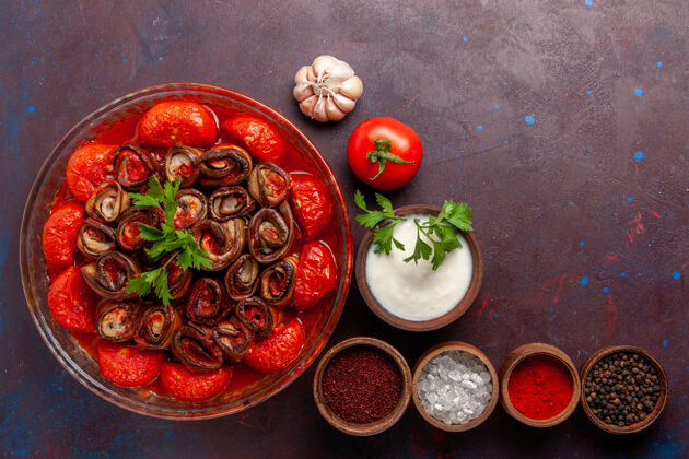 调味料顶视图熟蔬菜餐番茄和茄子与调味品在黑暗的表面生的蔬菜餐桌