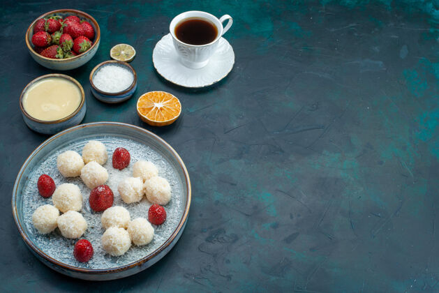 椰子美味的椰子糖配上新鲜的红草莓和一杯茶糖果营养品甜食