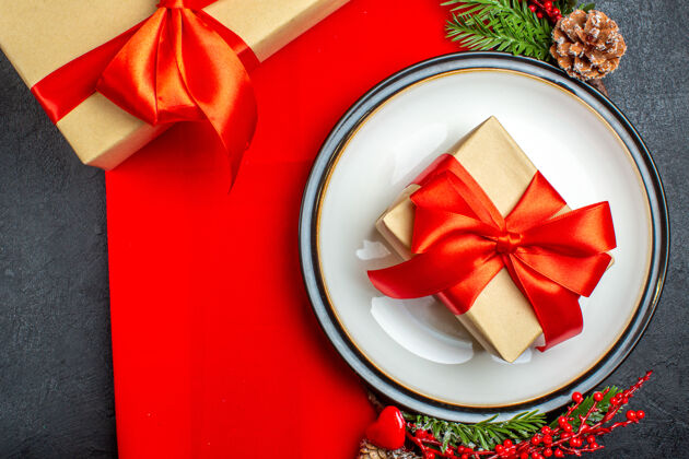 采购产品圣诞节餐盘上有礼物 冷杉枝上有装饰 红餐巾上有针叶树锥针叶树弓冷杉