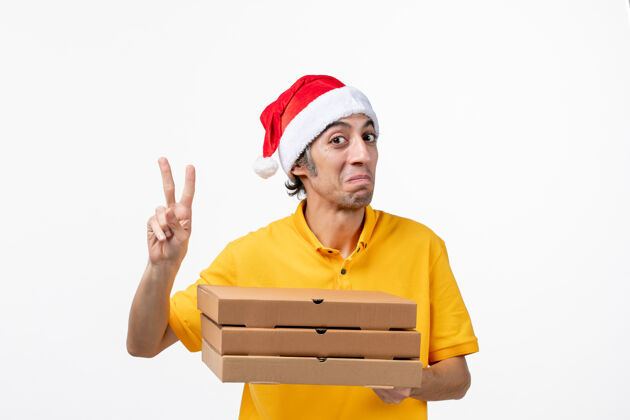 男人正面图男快递员拿着披萨盒在白墙上服务制服工作男信使工人微笑