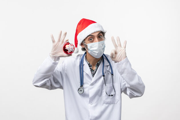 病毒白桌上戴着玩具面具的男医生健康病毒共度新年实验室外套男人听诊器