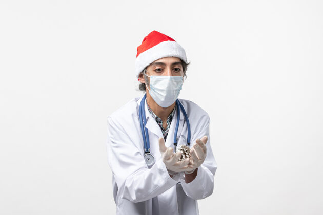 制服正面图男性医生拿着一个白墙病毒健康冠状病毒锥-圣诞节圆锥体视图听诊器
