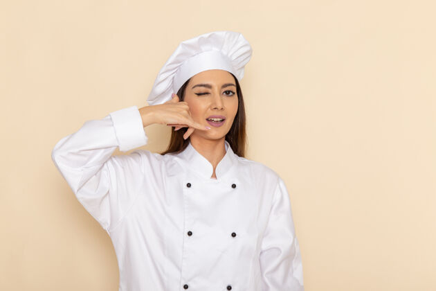 食物身穿白色厨师服的年轻女厨师在浅白的墙上眨眼专业烹饪人