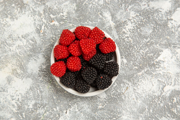 蛋糕顶部近距离观察新鲜浆果 在白色表面的盘子里装上甜糖果顶部草莓封闭的