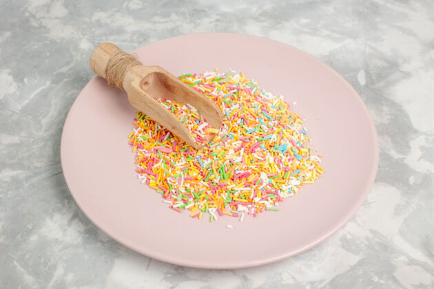 糖果盘子里五颜六色的小糖果的正面图配料一餐含糖