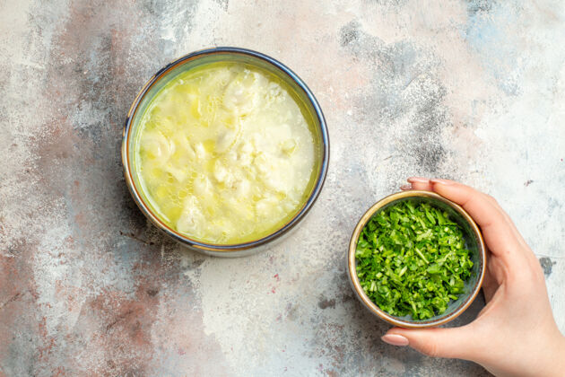 午餐俯视杜什巴拉饺子汤绿色碗在女性手上裸体表面与复制空间谷物汤碗