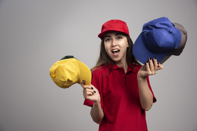 帽子一个穿着红色制服 戴着彩色帽子的送货员承运人女雇员