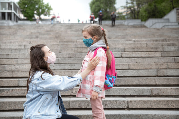 正常妈妈带着她的小女儿 一个女学生 踏上了上学的路冠状病毒大流行的教育理念友谊关系童年