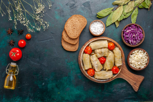 餐俯视图美味的肉食卷心菜和西红柿称为dolma油和深蓝色面包食物卷心菜肉