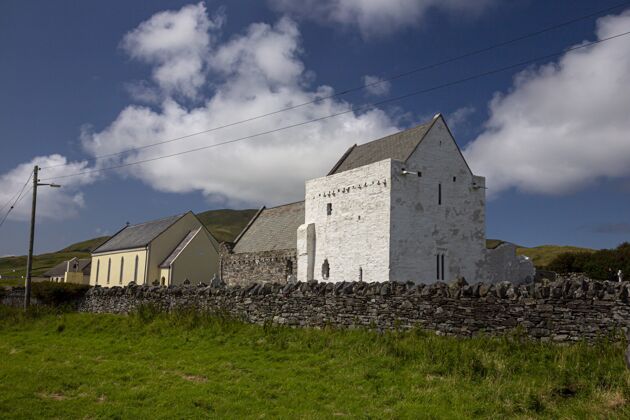 风景爱尔兰的克莱尔岛修道院在蓝天和阳光下绿树环绕海景美丽城堡